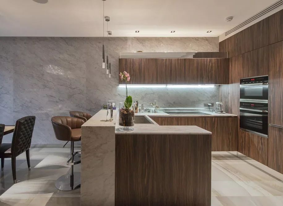 A kitchen with wooden cabinets and a bar.